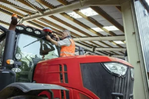 rolnik montujący GPS na traktorze